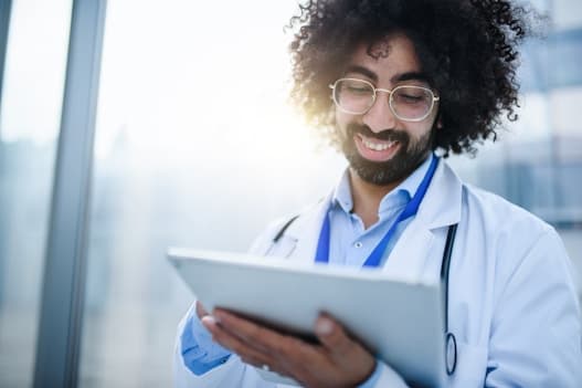 Doctor smiling and holding a tablet